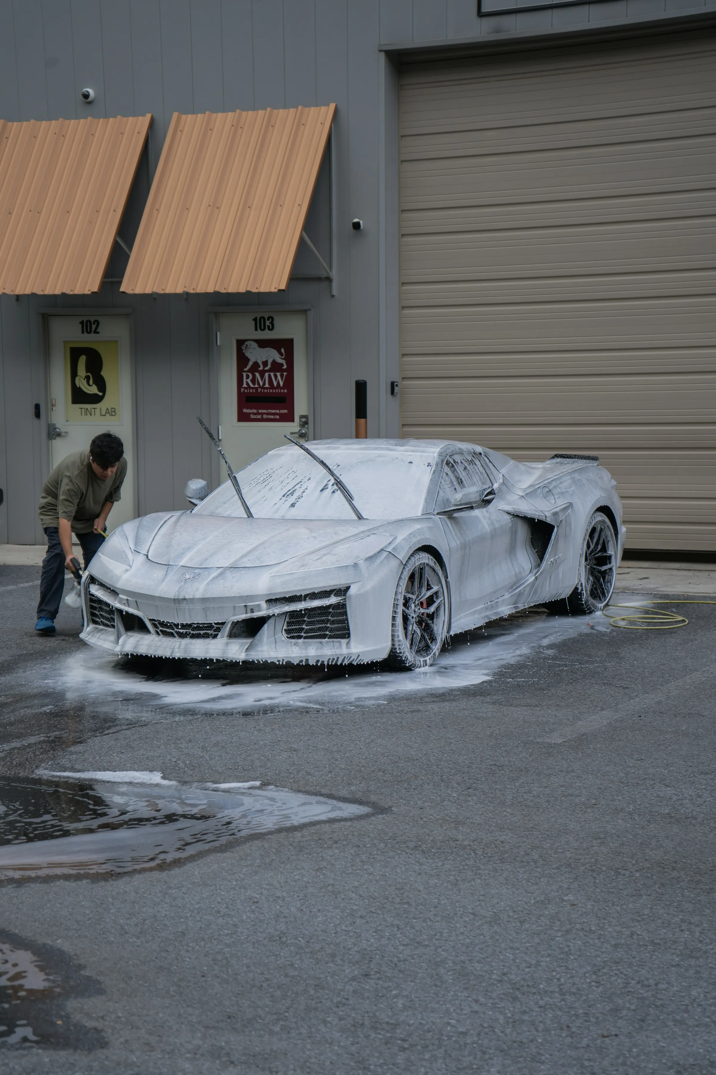 Carro esportivo coberto de espuma durante a pré-lavagem